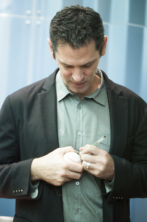 Shawn Green, a former MLB player, signs a ball after his talk at Gifford Auditorium on Monday. The Syracuse University Hillel Jewish Student Union Board invited Green to speak about how his baseball career helped shape his faith.