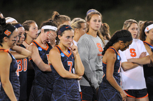 Syracuse players look on as Maryland celebrates its national championship victory