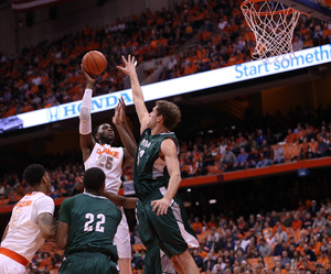 SU senior forward Rakeem Christmas lofts a shot over Loyola forward Franz Rassman in the Orange's 70-37 win.