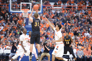 Long Beach State guard McKay LaSalle elevates to shoot a jumper as SU forward Michael Gbinije contests during Sunday afternoon's SU victory.