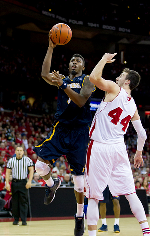 Justin Tuoyo goes up for a right-handed layup against perennial national player of the year Frank Kaminsky of Wisconsin. The Chattanooga big man lost his father when he was nine, and has dedicated his basketball career to giving back to his mother since then.