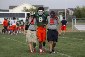 Steve Ishmael is helped off the field at Fort Drum on Tuesday after running into freshman Andrejas Duerig during a drill.