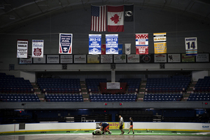 Workers lay down turf in the OnCenter War Memorial Arena  before the World Indoor Lacrosse Championship begins on September 18.