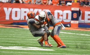 Two Syracuse defenders take down a Virginia Tech player. SU's defense had one of its best games this season, allowing fewer than 20 points for the second time this season and the first time against an FBS opponent. 