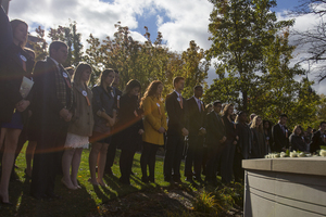 Remembrance scholars surround the memorial at the rose laying ceremony.