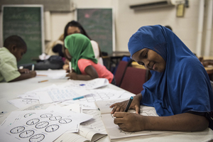 A girl is working on math problems after school through the RISE program.