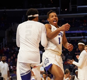 Desmond Bane (right) and Shawn Olden (left) shoulder bump during a game. 