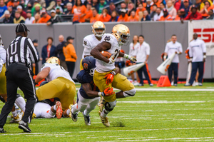 Josh Adams gets dragged down by a Syracuse defender during the teams' 2016 matchup at Metlife Stadium. 