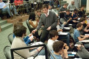 Student Association President Dylan Lustig, hands out slips of paper to members of the general assembly to cast their ballots on at Monday nights meeting held in Maxwell Auditorium.