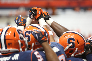 Members of the defense prepare to break a huddle during warmups prior to kickoff Friday night. 