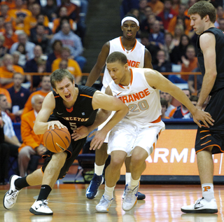 Princeton guard T.J. Bray is guarded closely by Brandon Triche as Triche goes high above a screen.