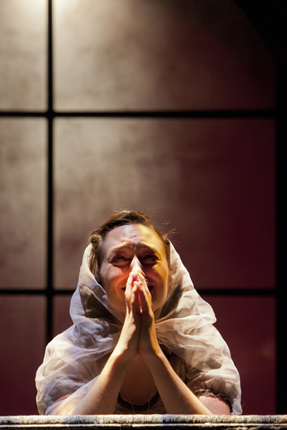 A character drops to her knees in prayer during SU Drama's production of ''Tis Pity She's a Whore.