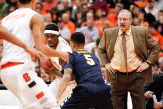 Canisius head coach Jim Baron looks on as Golden Griffins guard Reggie Groves defends Syracuse forward C.J. Fair.