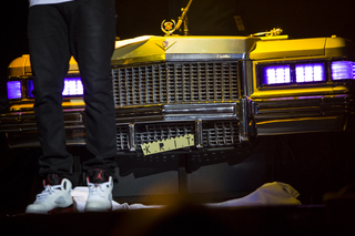 BIg K.R.I.T. stands in front of his DJ stand, made to look like the grill of a Cadillac.