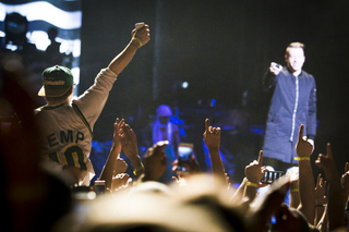 A crowd-surfing fan sporting a Seattle Supersonics jersey gains Macklemore's attention, since the rapper hails from Seattle. Macklemore said the audience member should be elected student body president.