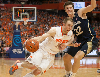 Cooney charges toward the basket, guarded by UND guard Steve Vasturia.