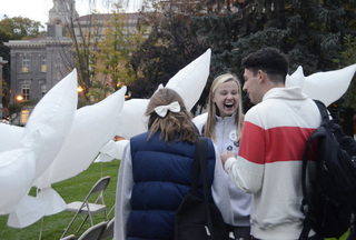 Karolina Lubecka, a senior civil engineering and earth sciences dual major and 2014 Remembrance Scholar, ties balloons to chairs on the Quad prior to the balloon release event on Monday. Thirty-five dove-shaped balloons were released on Monday night to represent each of the 35 Syracuse students killed in Pan Am Flight 103. 