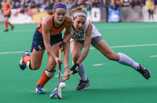 Syracuse junior midfielder Alyssa Manley fights against a UConn midfielder for possession of the ball.