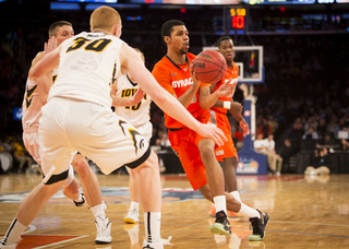 Gbinije drives the lane and look to kick it out as Iowa's Aaron White defends.