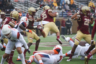 Rouse, a Baldwinsville, New York native, jumps in the air with the ball tucked in his right hand.