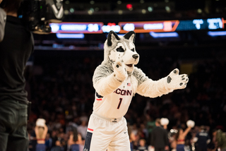 The Huskies mascot claps his hands. 